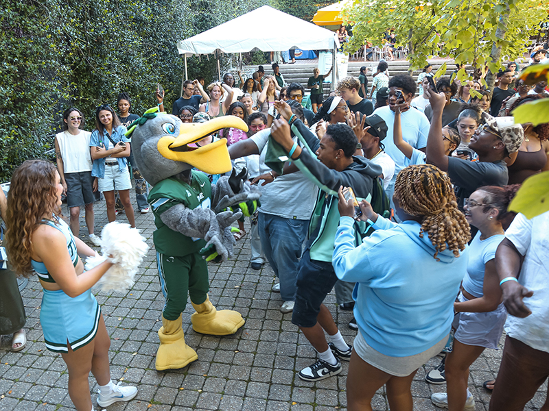 Riptide the pelican dances with Tulanians at commUNITY 2026.