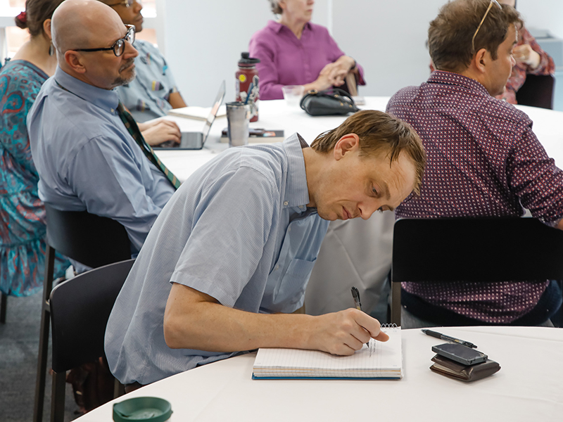 A Tulanian takes notes at a table at the Booked! workshop.