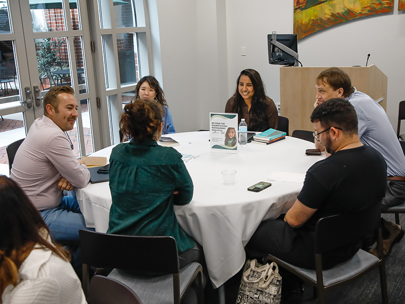 A group of Tulanians sit around a table discussing books at a Booked! workshop.