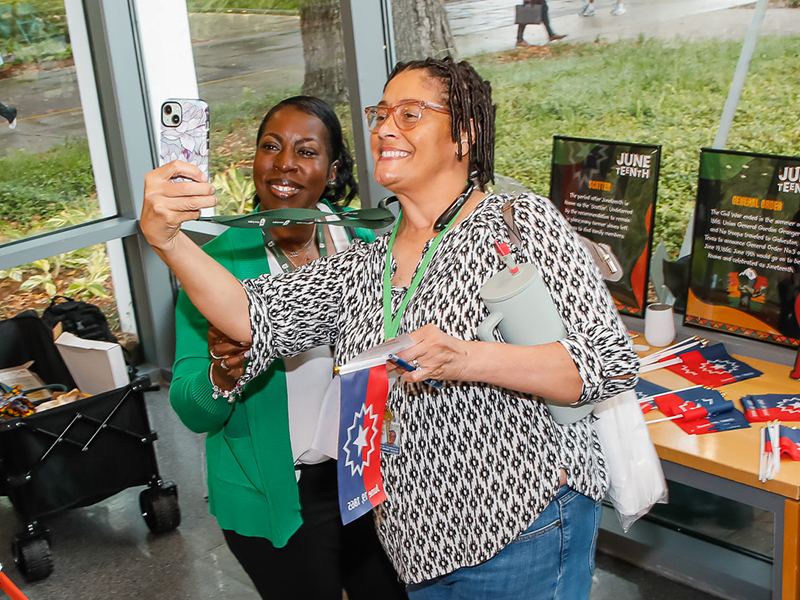 Two people pose for a selfie during Juneteenth on Tulane's Uptown campus.